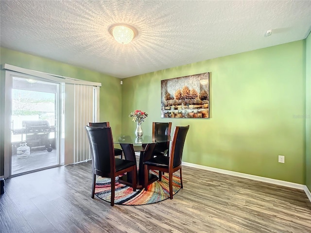 dining room featuring hardwood / wood-style floors and a textured ceiling