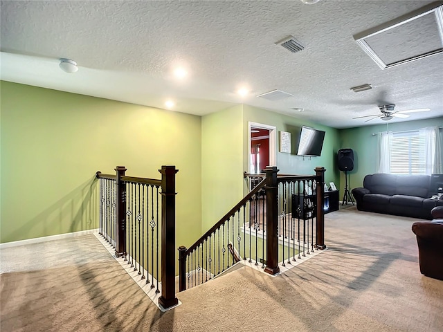 staircase featuring carpet flooring and a textured ceiling