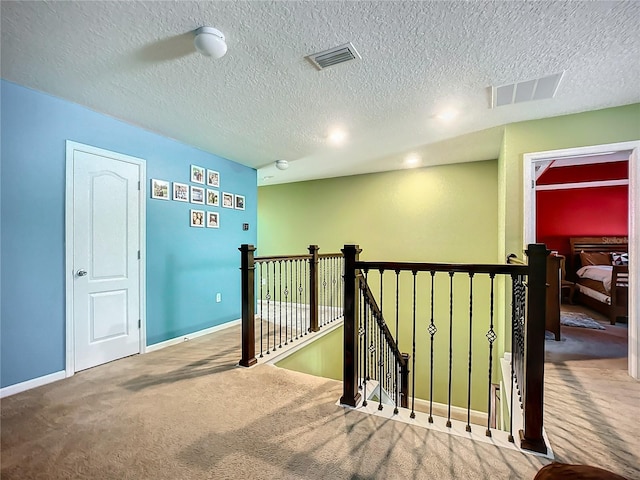 hallway featuring a textured ceiling and carpet