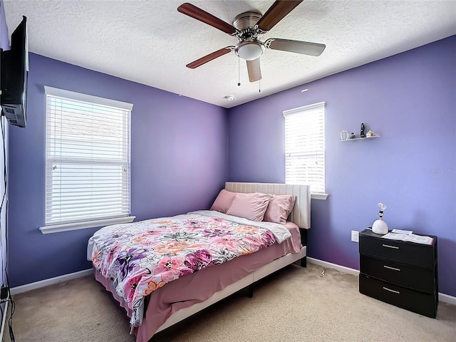 bedroom with light carpet, a textured ceiling, and ceiling fan