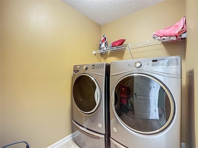 washroom with washing machine and dryer and a textured ceiling