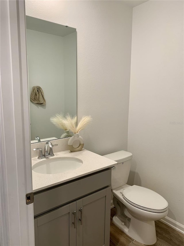 bathroom with vanity, hardwood / wood-style floors, and toilet