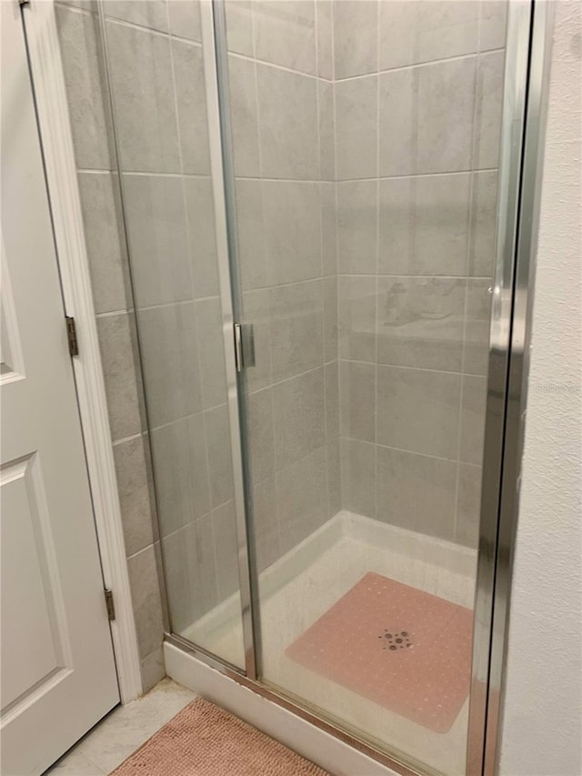 bathroom with tile patterned floors and a shower with shower door