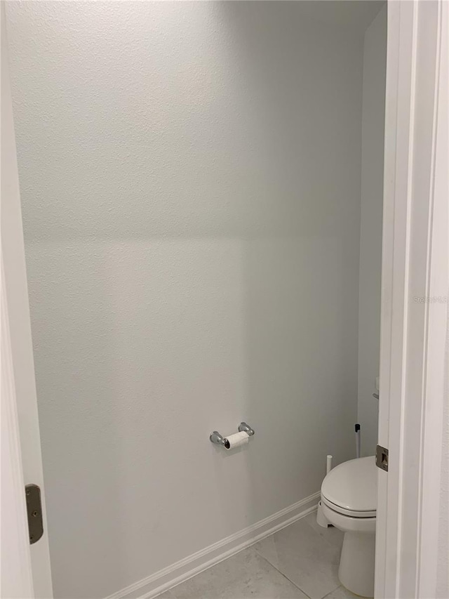 bathroom with toilet and tile patterned flooring