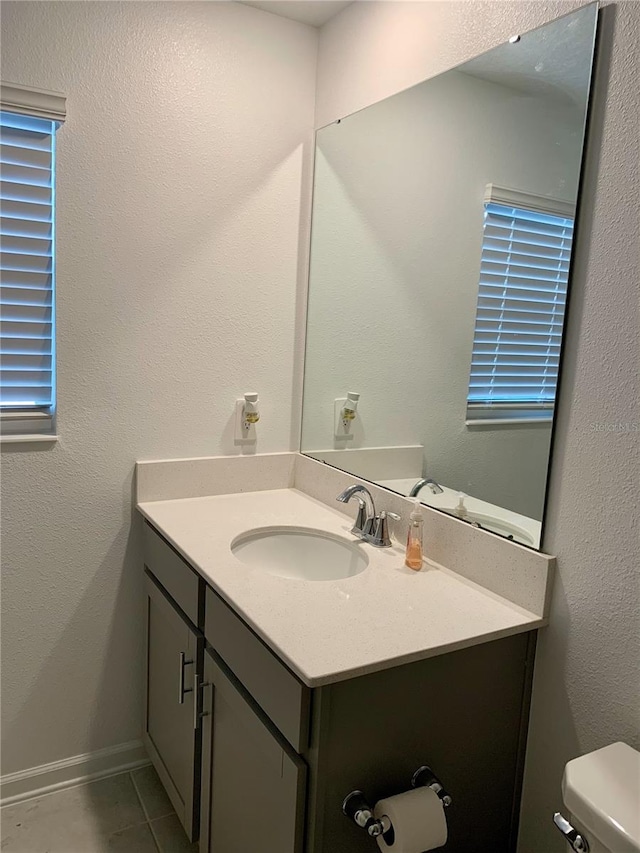 bathroom with vanity, toilet, and tile patterned flooring