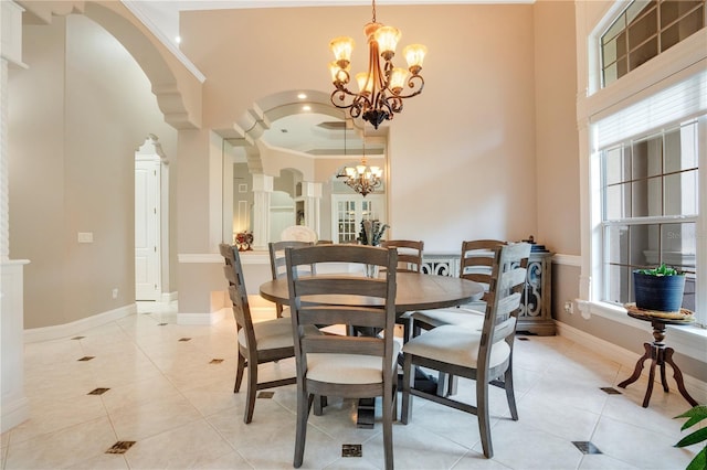 dining area featuring light tile patterned flooring, a healthy amount of sunlight, a chandelier, and a high ceiling