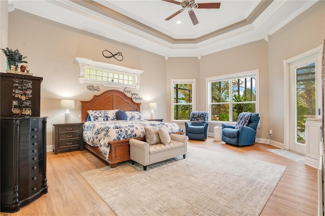 bedroom with crown molding, a tray ceiling, ceiling fan, and light hardwood / wood-style flooring