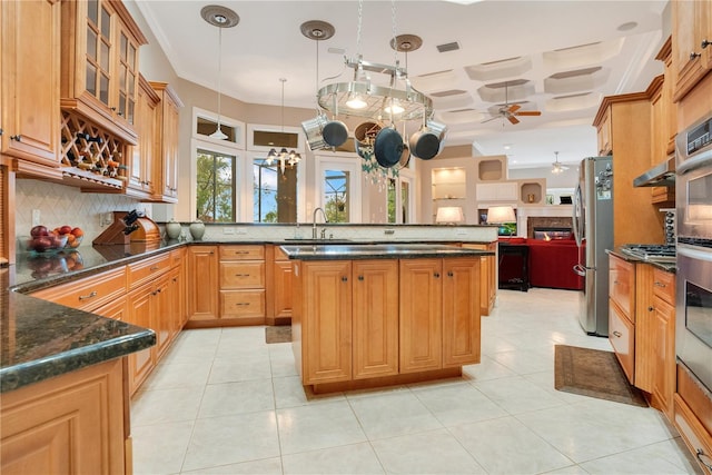 kitchen featuring hanging light fixtures, dark stone countertops, stainless steel refrigerator, and kitchen peninsula