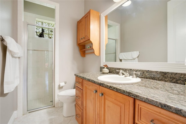 bathroom featuring walk in shower, vanity, toilet, and tile patterned flooring