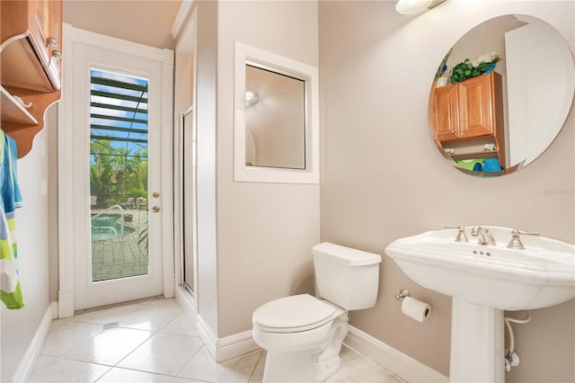 bathroom with an enclosed shower, sink, tile patterned floors, and toilet