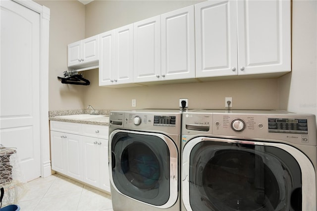 clothes washing area with light tile patterned flooring, cabinets, washer and clothes dryer, and sink