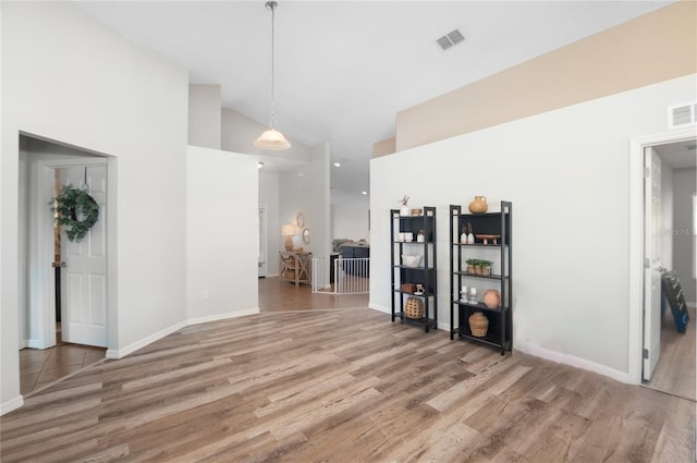 interior space featuring wood-type flooring and high vaulted ceiling