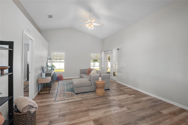 living room with ceiling fan, lofted ceiling, and light hardwood / wood-style flooring