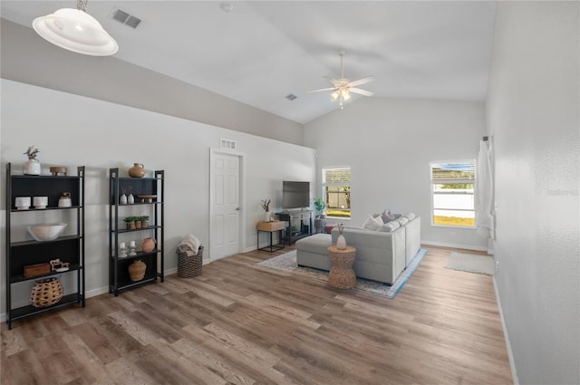 living room with wood-type flooring, ceiling fan, and high vaulted ceiling