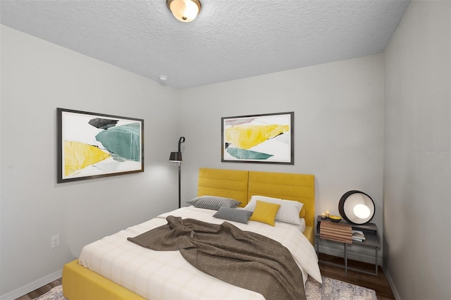 bedroom featuring wood-type flooring and a textured ceiling