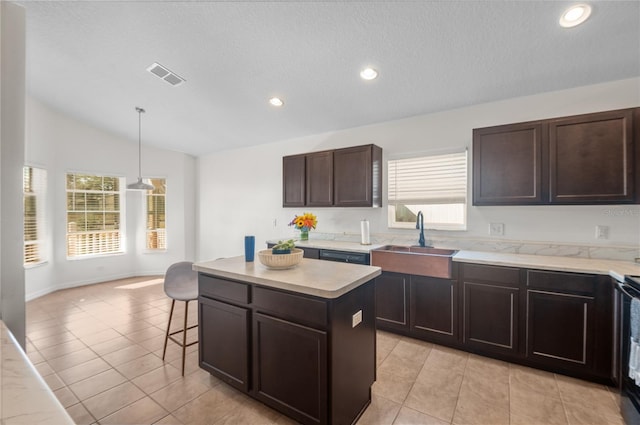 kitchen with vaulted ceiling, a kitchen island, light tile patterned flooring, decorative light fixtures, and sink