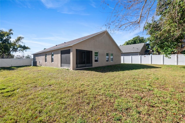 rear view of property featuring a sunroom, a yard, and cooling unit