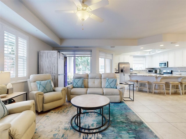 tiled living room featuring sink and ceiling fan