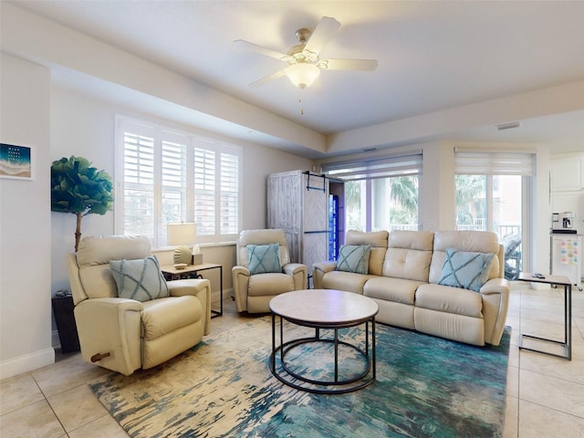 tiled living room with a wealth of natural light and ceiling fan