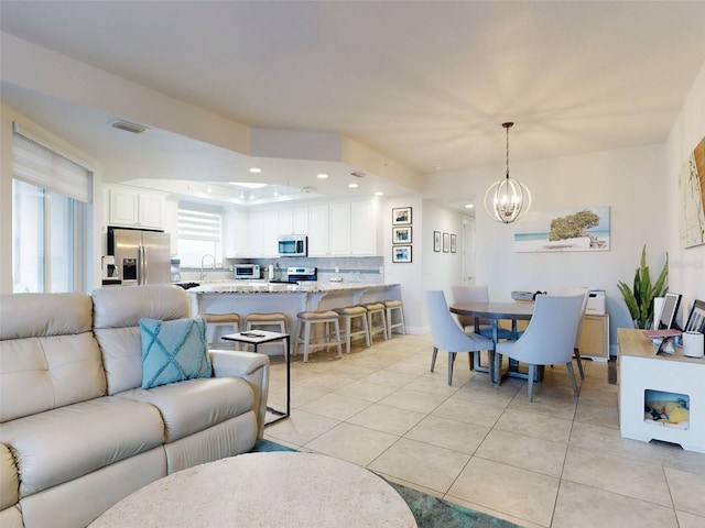 tiled living room with sink and a chandelier