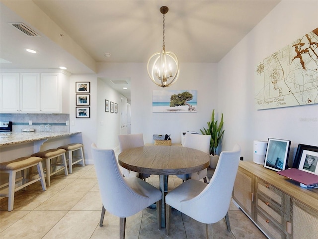 dining area with light tile patterned floors and a chandelier