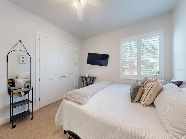 bedroom featuring ceiling fan, light colored carpet, and a closet