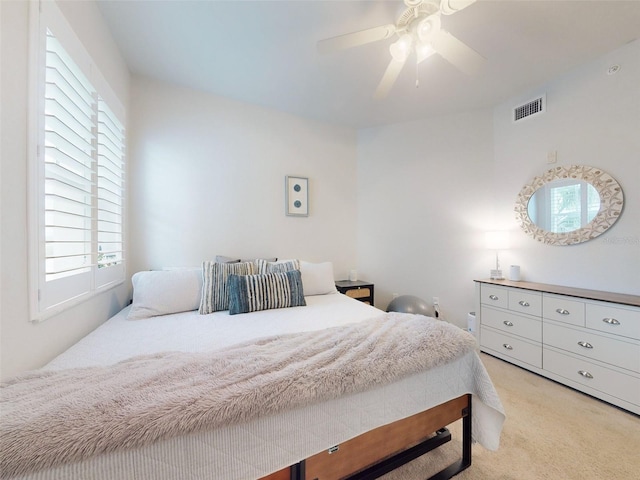 bedroom with ceiling fan and light carpet