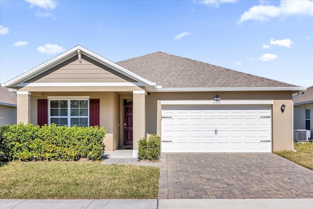 ranch-style house with a garage, a front lawn, and central air condition unit