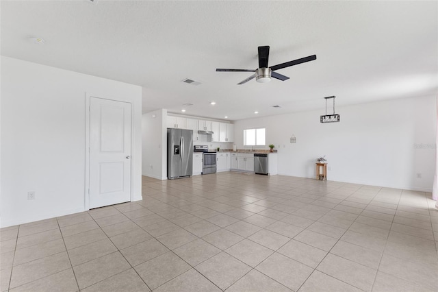 unfurnished living room with light tile patterned flooring, ceiling fan, and sink