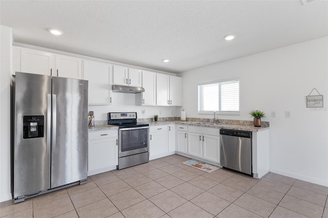 kitchen with light tile patterned flooring, appliances with stainless steel finishes, sink, and white cabinets