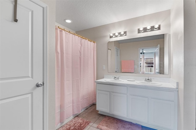 bathroom with tile patterned floors, curtained shower, vanity, and a textured ceiling