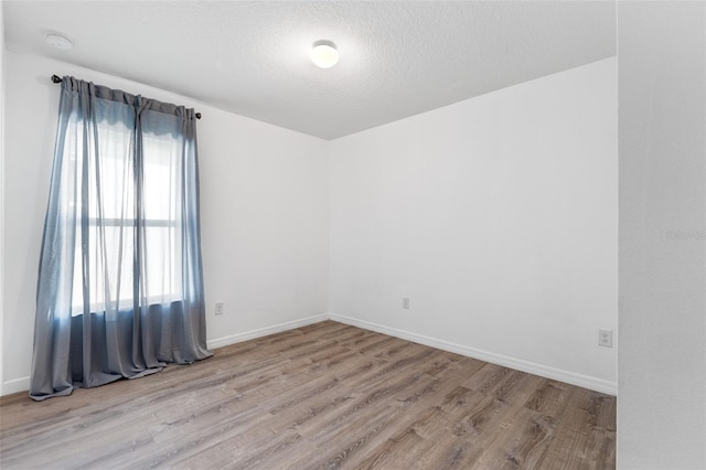 unfurnished room featuring a textured ceiling and light wood-type flooring