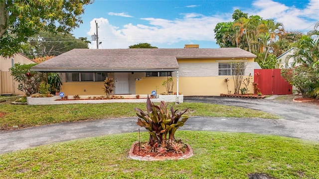 view of front facade featuring a carport and a front lawn