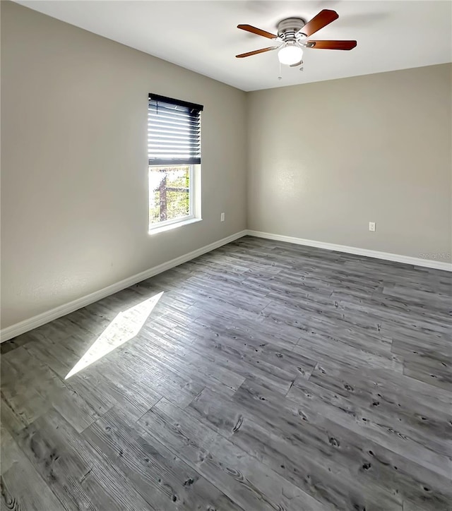 unfurnished room with dark wood-style floors, baseboards, and a ceiling fan