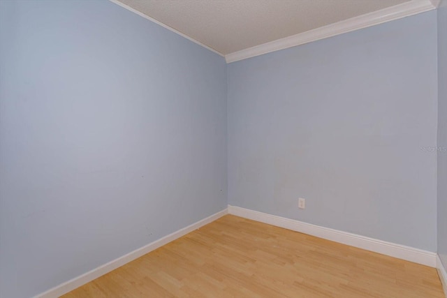 spare room featuring ornamental molding and light hardwood / wood-style floors