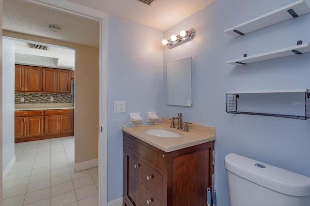 bathroom featuring tile patterned flooring, vanity, backsplash, and toilet