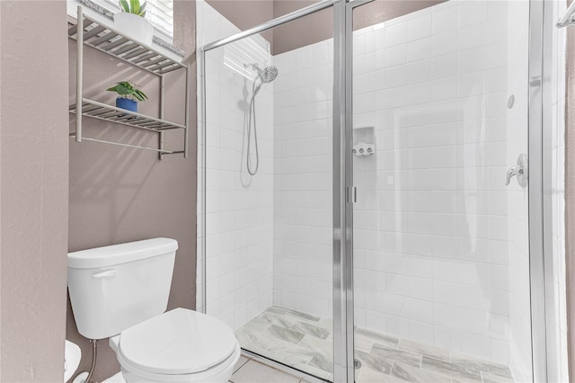 bathroom featuring tile patterned floors, toilet, and walk in shower