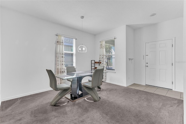 dining area with an inviting chandelier, plenty of natural light, and light colored carpet