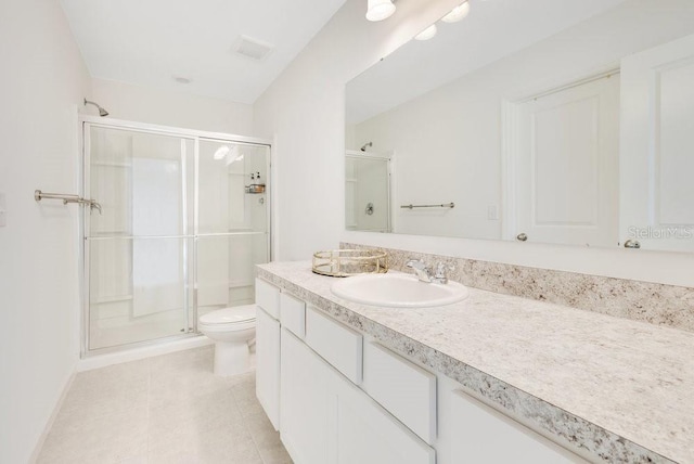 bathroom with tile patterned floors, vanity, toilet, and a shower with door