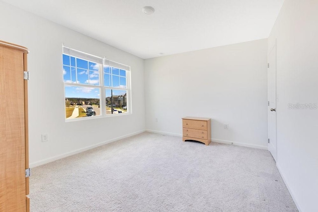 unfurnished room featuring light colored carpet