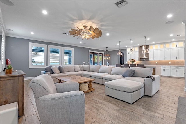 living room featuring ceiling fan, ornamental molding, and light hardwood / wood-style floors