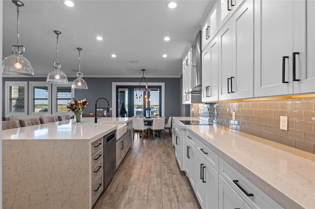 kitchen featuring a large island, decorative light fixtures, sink, and white cabinets