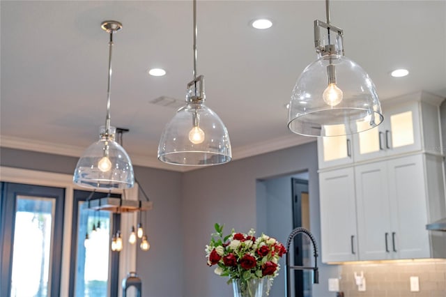 interior details featuring crown molding, decorative backsplash, and white cabinets