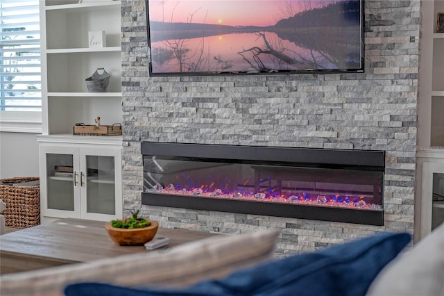 interior details with a stone fireplace and built in shelves