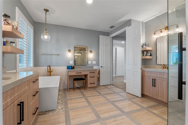 bathroom featuring vanity, tile patterned flooring, and a tub