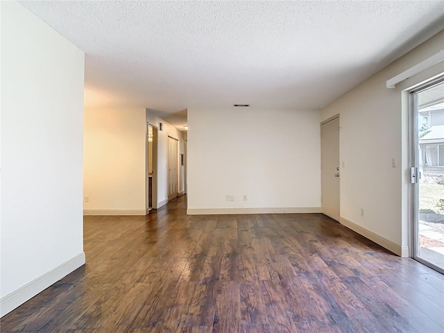 spare room with dark wood-type flooring and a textured ceiling