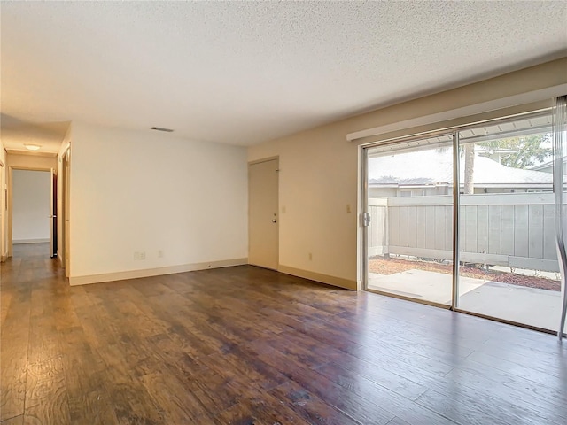 empty room featuring wood-type flooring and a textured ceiling