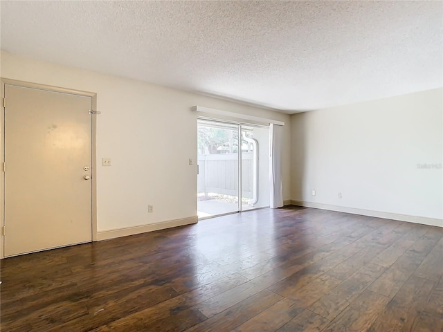 spare room featuring dark hardwood / wood-style flooring and a textured ceiling