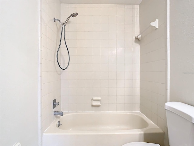 bathroom with tiled shower / bath and toilet