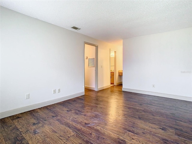 unfurnished room with dark hardwood / wood-style flooring and a textured ceiling